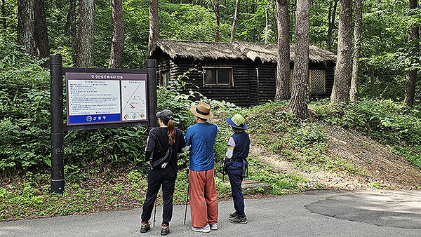 국립 청옥산 자연 휴양림 이용객이 산책 중 무림당의 안내를 보고 있다.